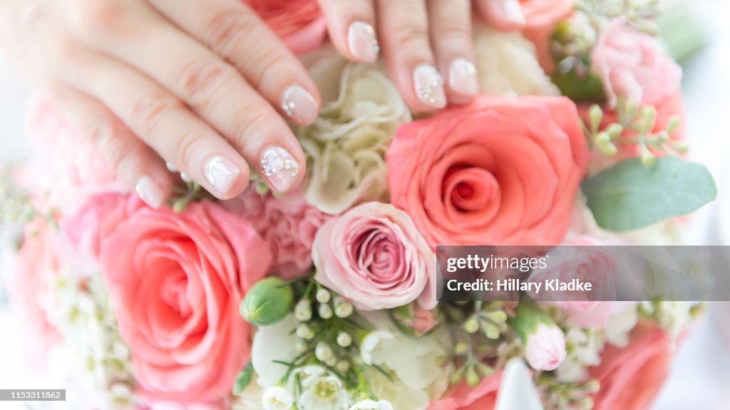 Manicured hands on rose bouquet