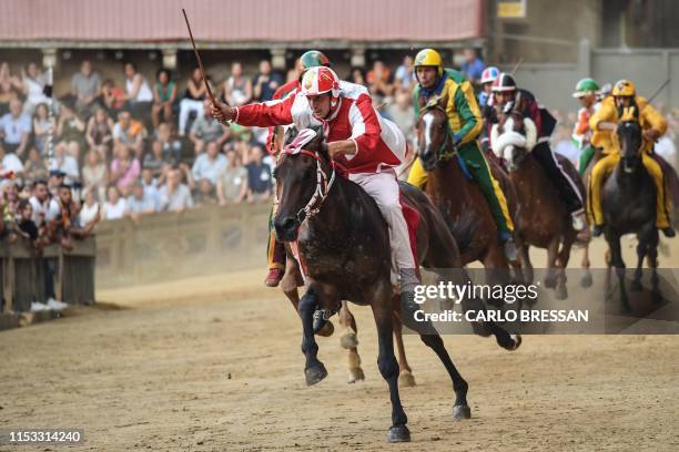 Jockey of the the contrada "Giraffa" Giovanni Atzeni, known as "Tittia" rides his horse Tale e Quale on his way to win the Palio di Siena horse race...