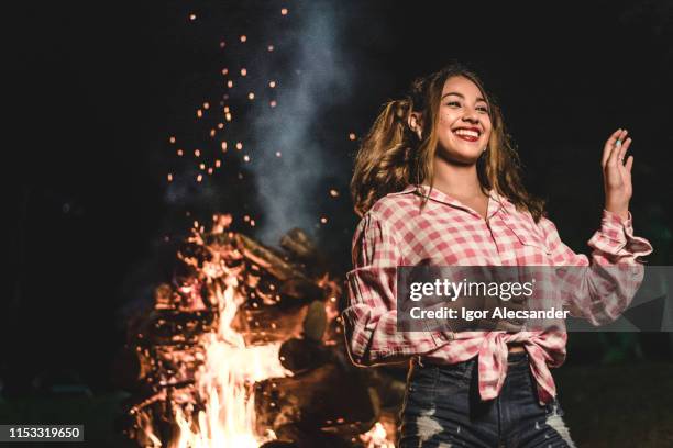 junge frau plaid hemd kostüm-party junina in der nähe von lagerfeuer - holzfeuer stock-fotos und bilder