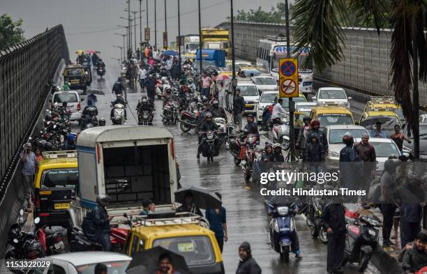 People were stranded due to water on a flooded street after heavy rain showers at Gandhi Market, Sion on July 1, 2019 in Mumbai, India. Heavy rains...