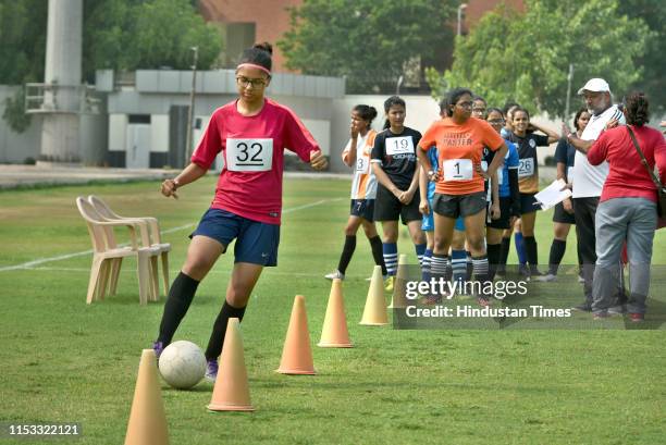 Students play football during the sports trials for their admission in the new academic year of Delhi University at Sports Ground, North Campus, on...