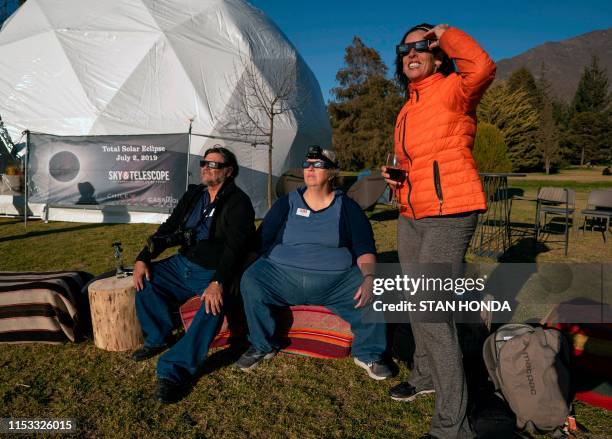 Charles Wiggins , Toni Moore , both from Tucson, US, and June Zehr of Woodstock, Canada watch the total solar eclipse from El Molle, Chile, July 2,...