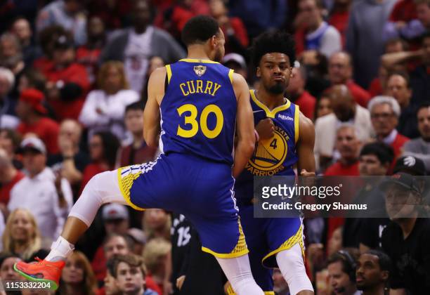 Quinn Cook and Stephen Curry of the Golden State Warriors celebrate the play against the Toronto Raptors in the second half against the Toronto...