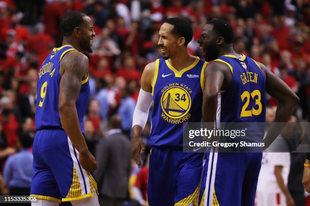 Andre Iguodala is congratulated by his teammates Shaun Livingston and Draymond Green of the Golden State Warriors after scoring a basket against the...