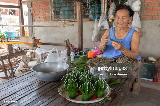 woman making bai sii from banana leaves. - tim bewer fotografías e imágenes de stock