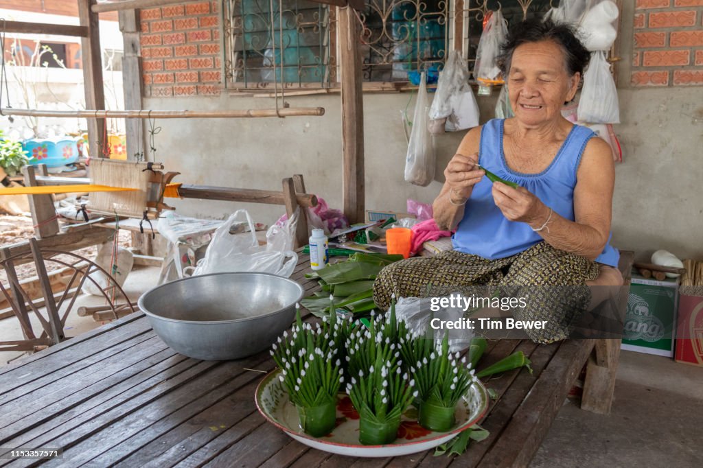 Woman making bai sii from banana leaves.