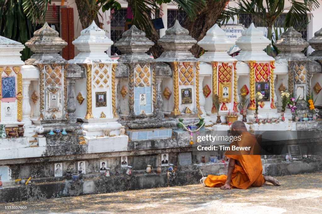 Monk in front of crypt for people's ashes.