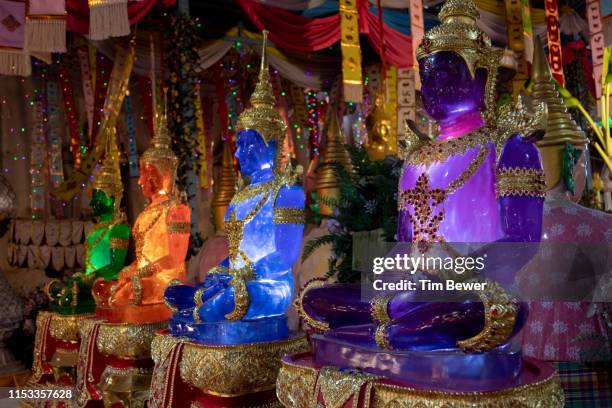 glowing buddha statues. - tim bewer fotografías e imágenes de stock