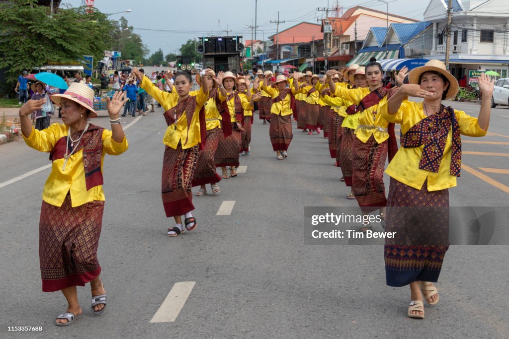 Women in traditional Thai clothes dancing in parade.
