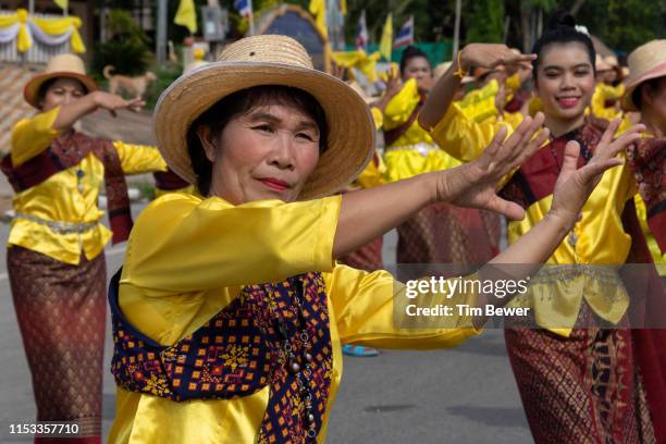 women in traditional thai clothes dancing in parade. - tim bewer fotografías e imágenes de stock