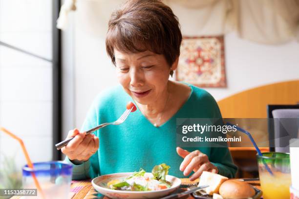 eating healthy food - senior adult eating stock pictures, royalty-free photos & images