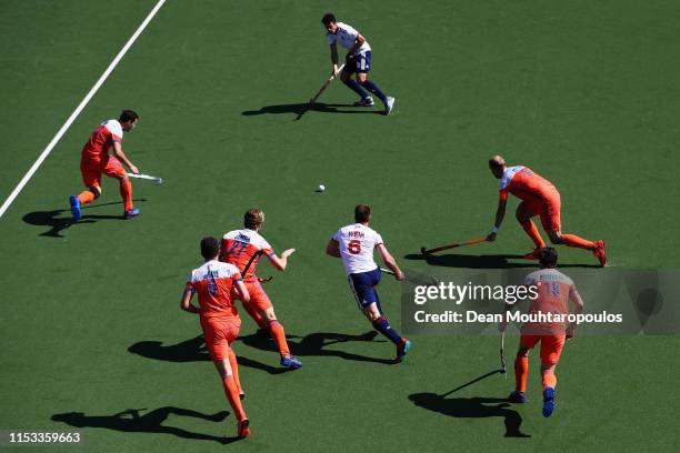 Henry Weir of Great Britain passes to team mate Mikey Hoare during the Men's FIH Field Hockey Pro League match between Netherlands and Great Britain...