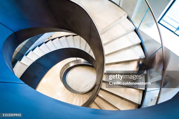 blurred motion of person on abstract spiral staircase - architecture curve stock pictures, royalty-free photos & images