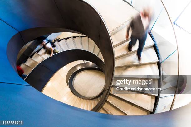 flou de mouvement des personnes sur l’escalier en spirale abstrait - businessperson stairs photos et images de collection