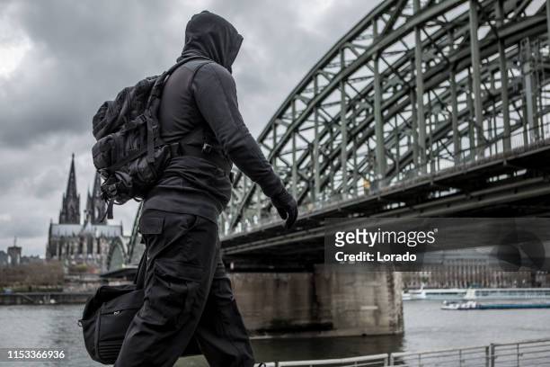 figura terrorista oscura encapuchado en colonia - terrorist fotografías e imágenes de stock