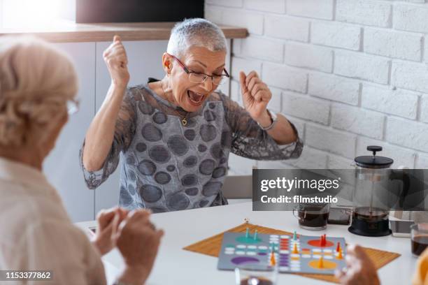 senior women playing boardgames - short game stock pictures, royalty-free photos & images