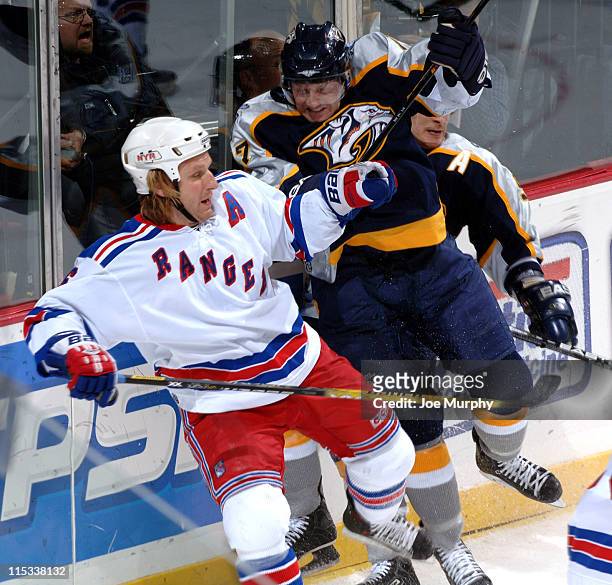 Rangers Darius Kasparaitis is checked by Scott Hartnell of the Predators during the game between the New York Rangers and the Nashville Predators at...