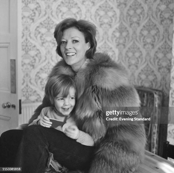 English actress Maggie Smith, wearing a fur coat, with her son Chris Larkin, UK, 21st April 1970.