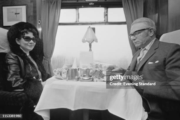 English actress Joan Plowright and English actor and director Laurence Olivier drink tea on a train carriage, UK, 17th April 1970.