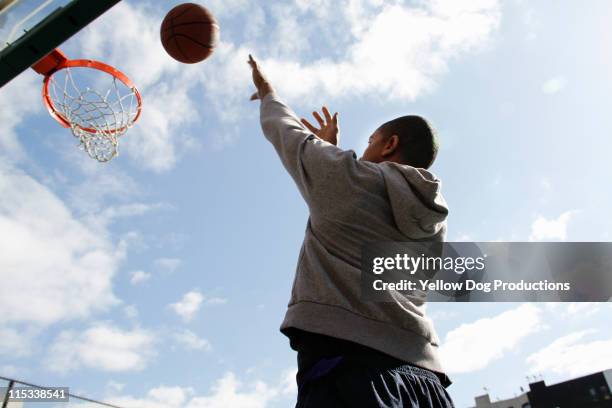 young adult man playing basketball - man 30s stock pictures, royalty-free photos & images