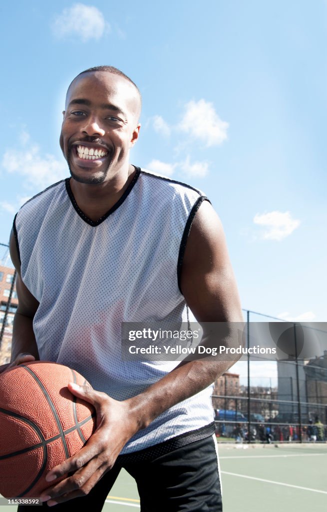 Young Smiling Adult Man Playing Basketball