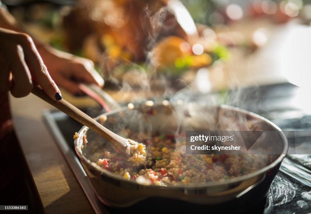 Close up of unrecognizable woman preparing lunch in the kitchen.