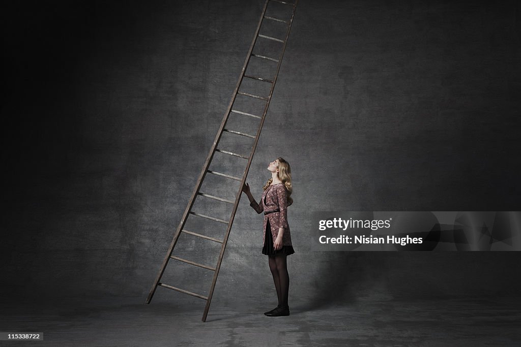 Business woman holding ladder