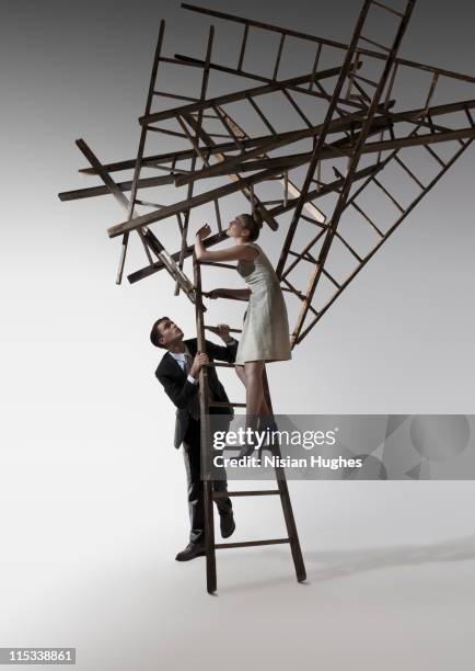 cluster of ladders falling on man and woman - caught in the act stockfoto's en -beelden