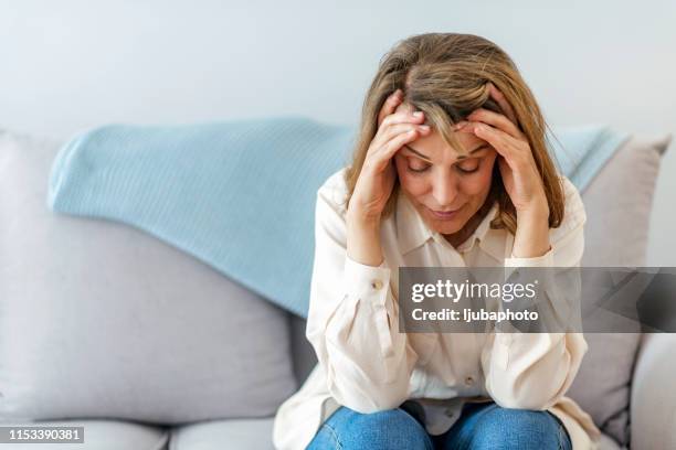 da dove viene questo mal di testa all'improvviso? - menopausa foto e immagini stock
