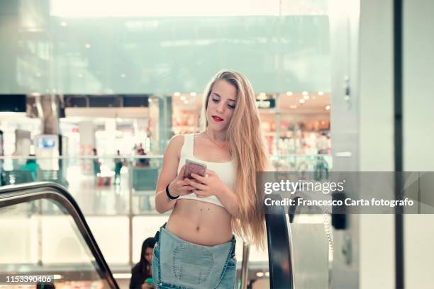 young woman checking her smartphone - milan airport stock pictures, royalty-free photos & images