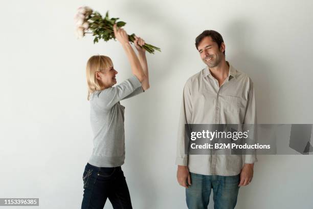 woman hitting bouquet on man's head - wife battering stock pictures, royalty-free photos & images