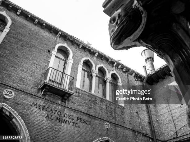 un dettaglio dell'antico mercato del pesce di rialto lungo il canal grande nel cuore storico di venezia - rialto bridge foto e immagini stock