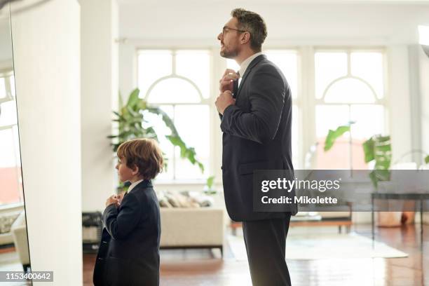 dapper papá y su pequeño amigo - traje fotografías e imágenes de stock