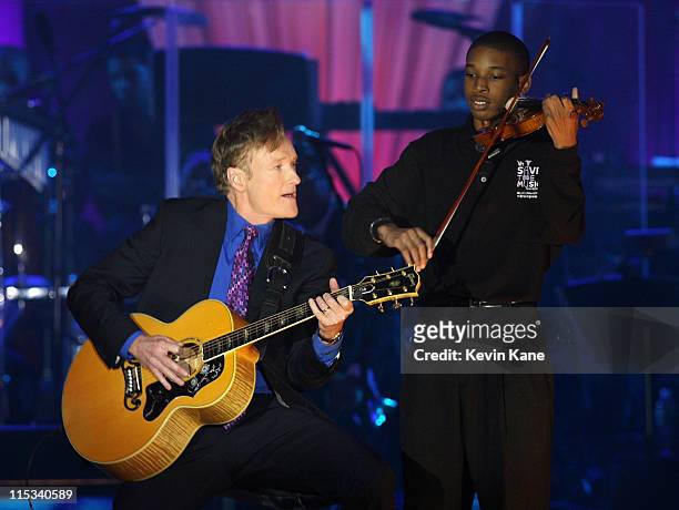 Personality Conan O'Brien and a Save The Music student perform during the VH1 Save The Music Foundation Gala at the Tent at Lincoln Center on...