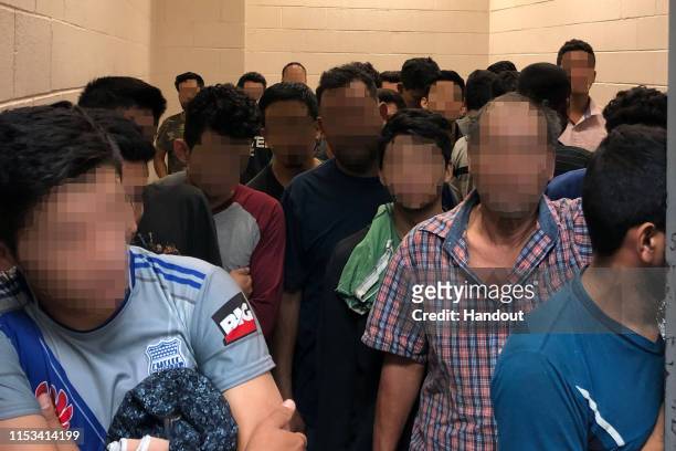 In this handout photo provided by the Office of Inspector General, adult males are detained in a cell with standing room only, as observed by OIG at...