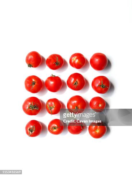 red tomatoes on white background - cherry tomatoes stock-fotos und bilder