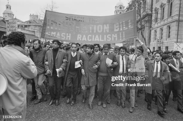 Demonstrators marching down Whitehall to protest against the British Government's new immigration bill, London, 21st March 1971. Second from left is...