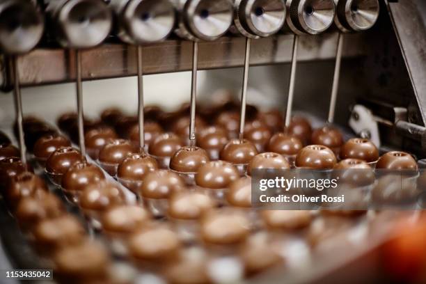 machine filling chocolate confectionery with liquid - chocolate factory stockfoto's en -beelden