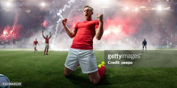 professional soccer player celebrating on knees in stadium with flares - distress flare stock pictures, royalty-free photos & images