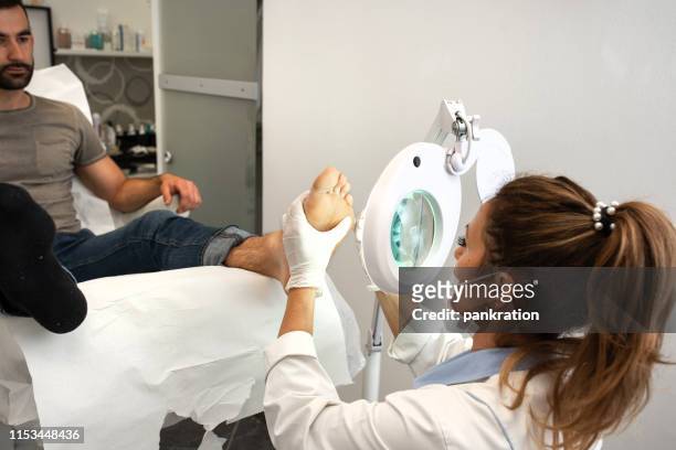 professional pedicure using electric machine to remove foot calluses - warts stock pictures, royalty-free photos & images
