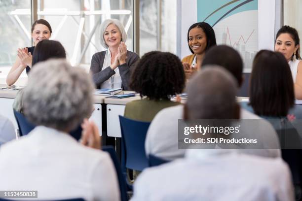 multi-ethnic panel for small business expo applauds audience. - q and a panel stock pictures, royalty-free photos & images