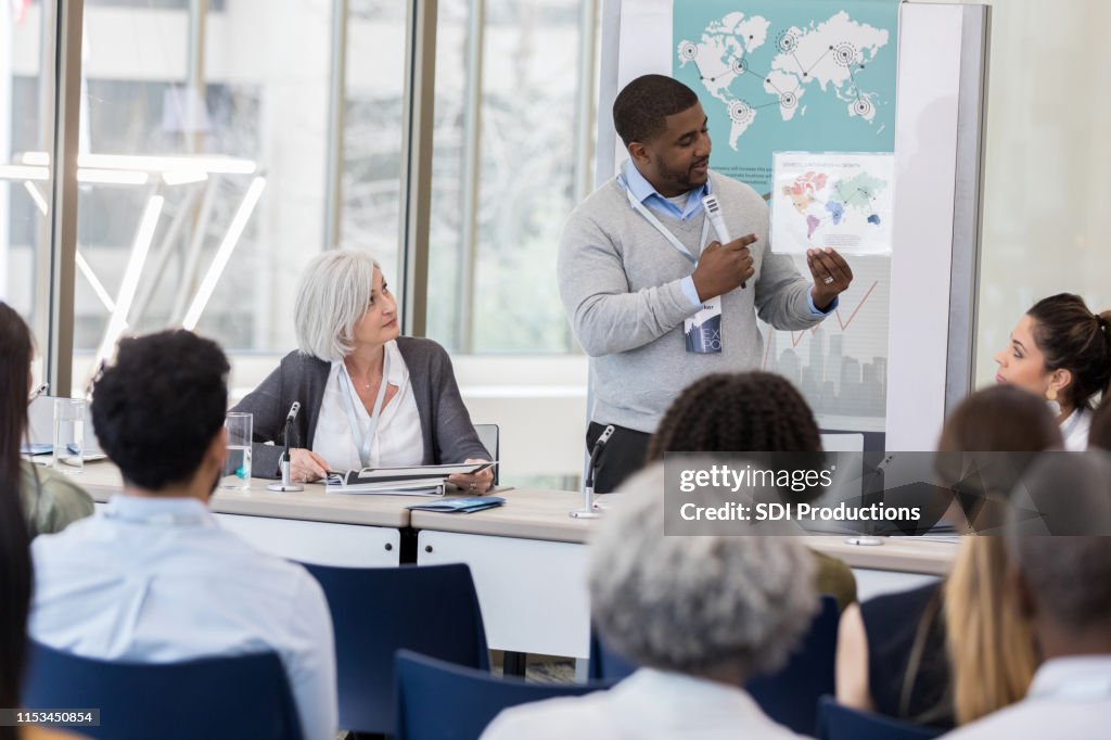 Mid adult businessman shows results of global loan program
