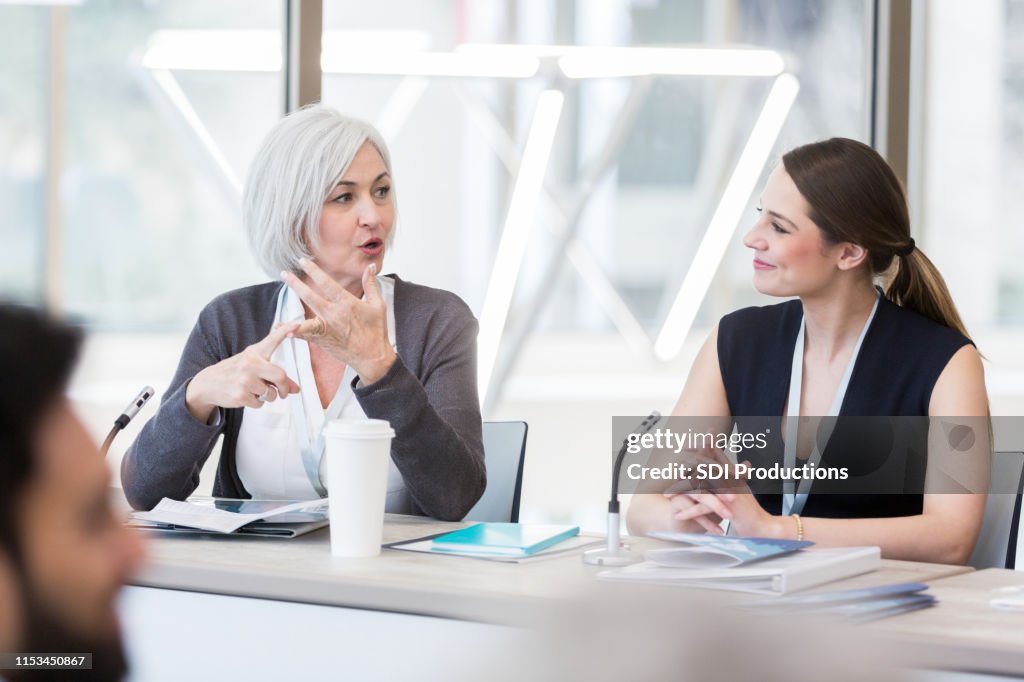 Mature adult woman sets out points for discussion during expo