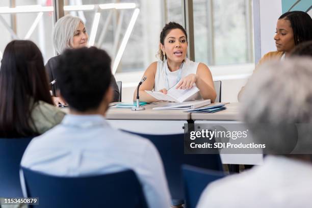 mid adult hispanic woman explains that day's expo schedule - local government building stock pictures, royalty-free photos & images