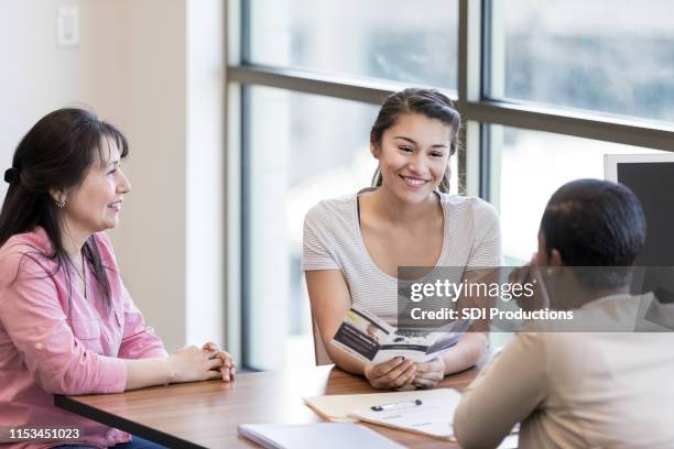 jonge vrouw praat over student lening met lening officier - investment brochures stockfoto's en -beelden