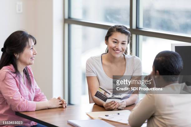 young woman talks about student loan with loan officer - credit union stock pictures, royalty-free photos & images