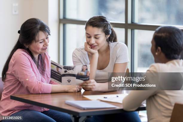 young woman and her mom review bank pamphlet - terms and conditions stock pictures, royalty-free photos & images