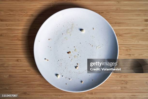 empty breakfast dish with bread crumbs on a bamboo wooden table - empty plate stock pictures, royalty-free photos & images