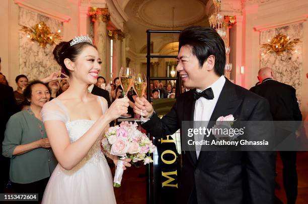 Pianists Lang Lang & Gina Alice drink a glass of Moet et Chandon Champagne during their Cocktail Wedding at Hotel Shangri-La on June 02, 2019 in...