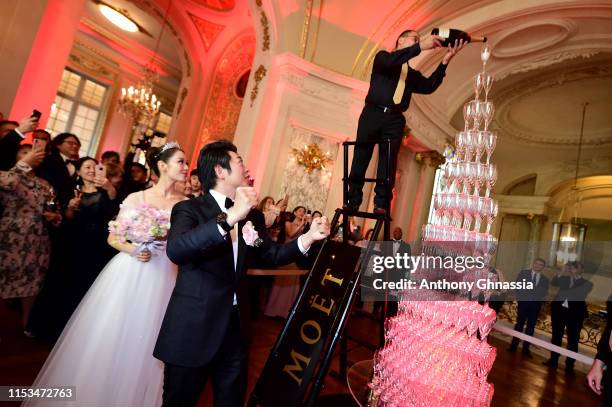 Pianists Lang Lang & Gina Alice celebrate their wedding in front of a Moet et Chandon Champagne pyramid during their Cocktail Wedding at Hotel...